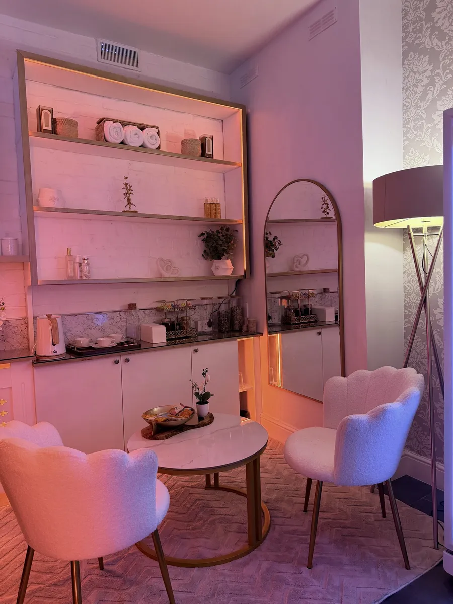 The softly lit reception area at Vora Wellness with two bouclé chairs